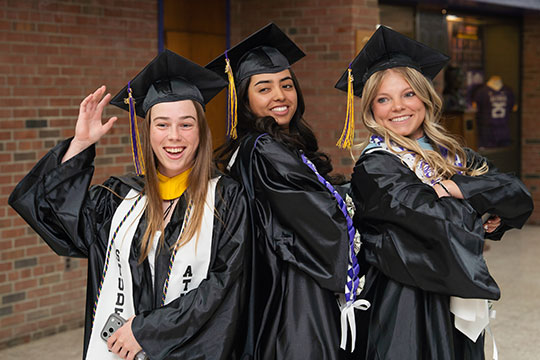 three young women in caps and gowns