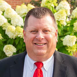 headshot of man with uit and tie