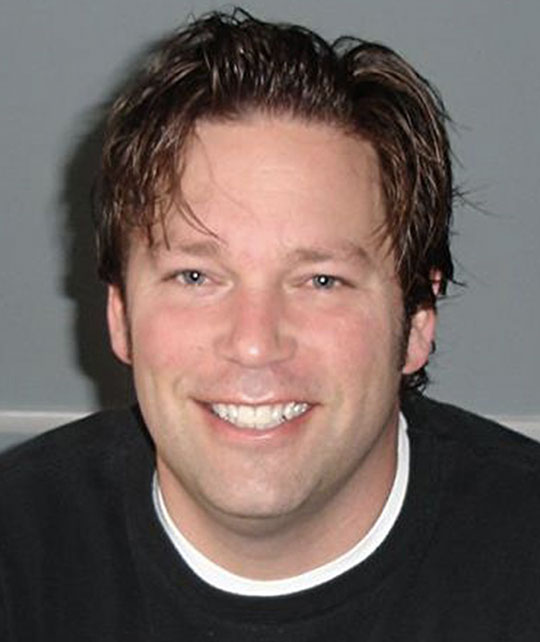 headshot of a man with dark hair and dark sweater