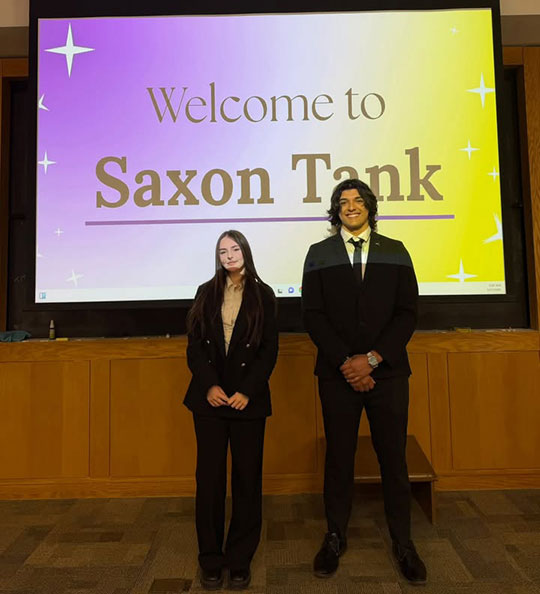 a young woman and man standing in front of a projector screen