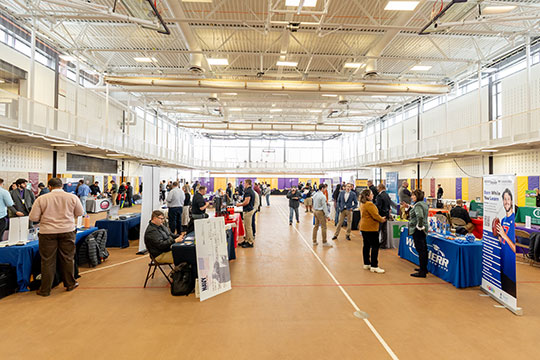 group of people gathered around tables in a large space