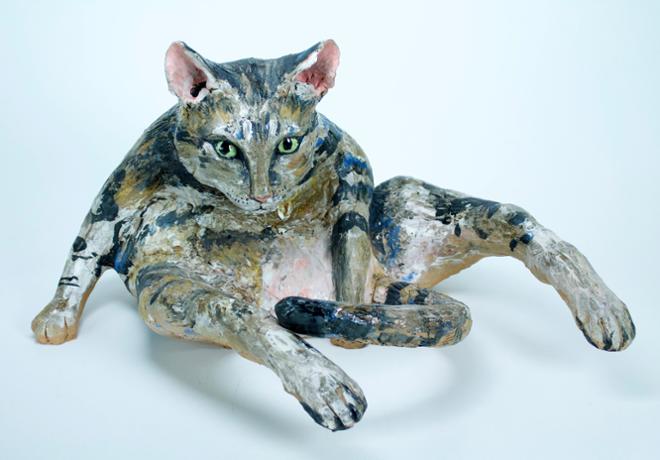 A funny sculpture of a cat whose eyes are stunned to see you. 
