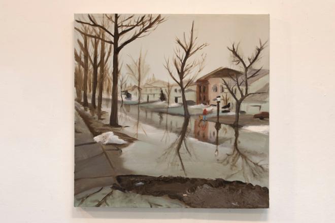 A flooded suburban street. Two figures in raincoats stand in the distance. 