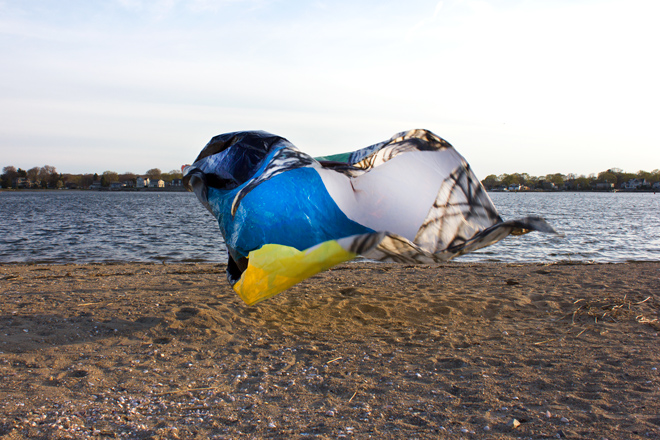 painting of colorful cloth floating in breeze on a beach