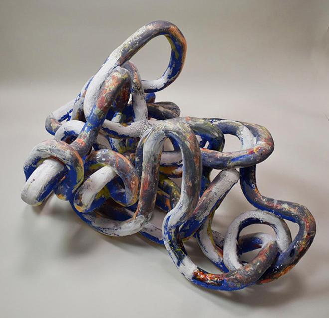 An abstract ceramic form consisting of vine like shapes interlocking. 
