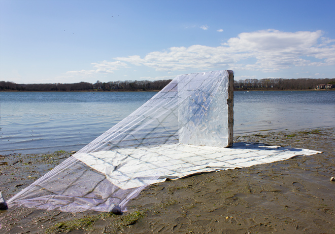 painting of blanket, a vertical block, with draping mesh on a beach
