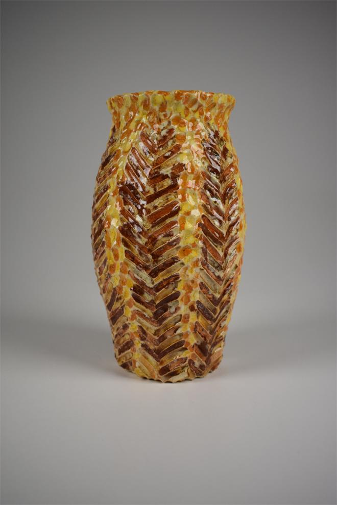 Hand carved ceramic vase with abstracted fern leaf designs.