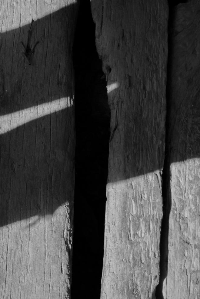 Barn Boards with a hole that's black and shadows over them.
