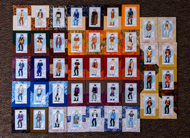 43 drawings of characters in various costumes, each mounted to colorful fabric-covered boards, displayed in a rectangular, grid-like formation 