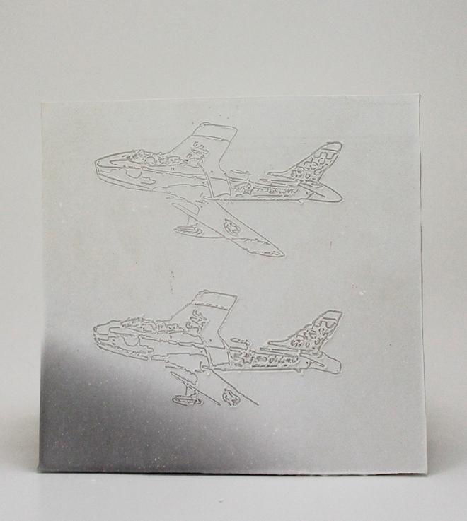 Line drawings of two F-86 Sabre jets etched into ceramics.