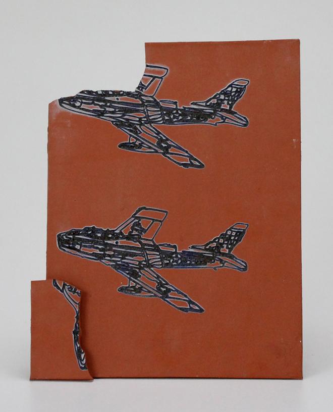 Blue line drawings of F-86 Sabre Jets laser etched into red clay.