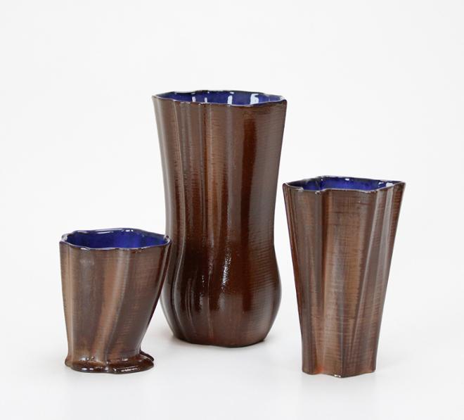 Three soda fired cups in a row. All with blue shiny interiors.