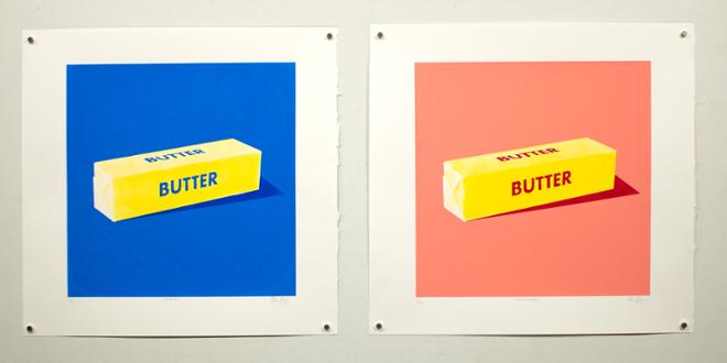 Two square prints, each on white paper with a deckled edge with a white border. On the left, a stick of butter with blue writing and a dark blue background. On the right, a stick of butter with red writing and a pink background.
