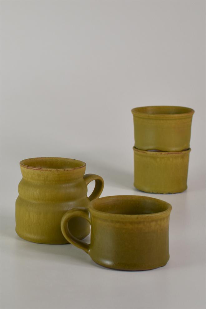 Set of four miscellaneous thrown cups and mugs glazed in raw sienna