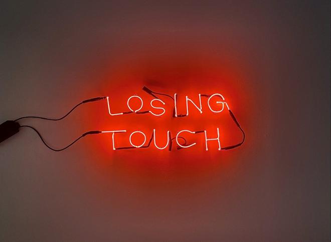 A neon text piece reciting the words “Losing Touch” in Red Neon 