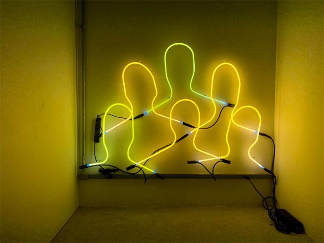 Neon tubes bend into the form of heads installed a little to close for comfort 