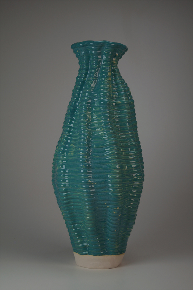 Coil built vessel, tall full body, with a turquoise shiny glazed.