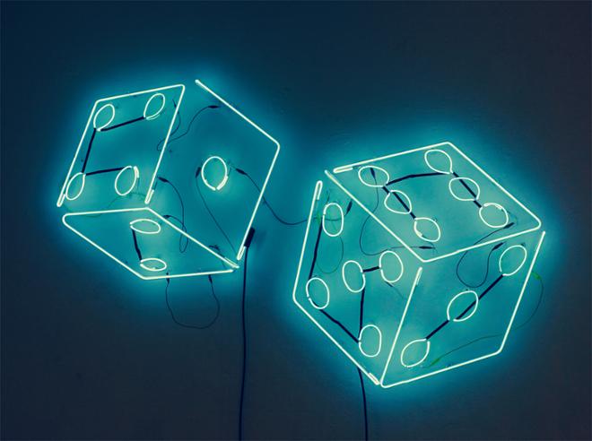 A blue neon sign of dice appearing as if they are mid roll.