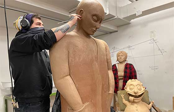 tyler on the right working on a larger than life clay sculpture