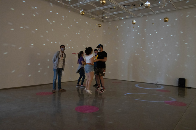 people moving around a room with moving light projections