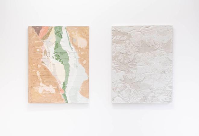 Diptych installation of two plaster paintings. The left painting resembles an abstract landscape with bright pastel browns, greens, blues, and pinks. The plaster is poured to look layered like typography. The painting on the right is a close up of a real tree camo pattern. The pattern is embedded into the surface of the plaster, appearing to be there and not there. It Is a neutral grey green color and leaf shapes appear on the surface with textures from canvas.  