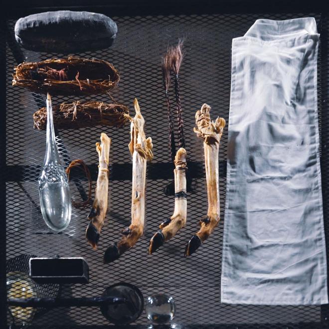 From right to left: niqab, deer hooves, hair, crystal ball, candle, rubber bands, glass bottle containing lubricant, dried plants, match sticks.