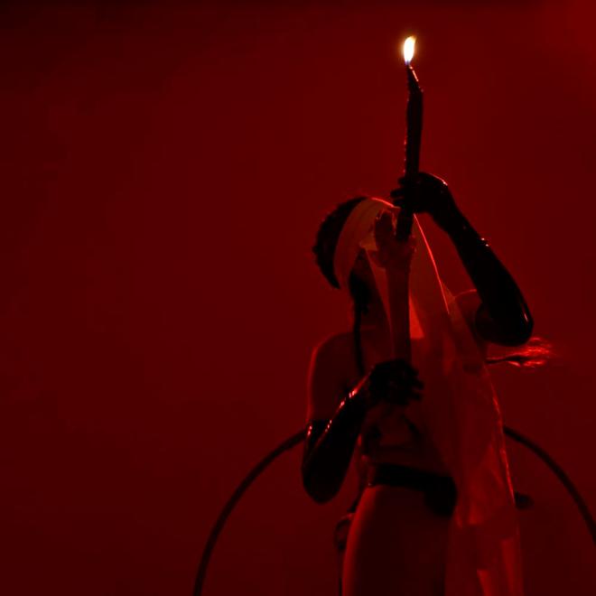 An individual performing in red lighting.