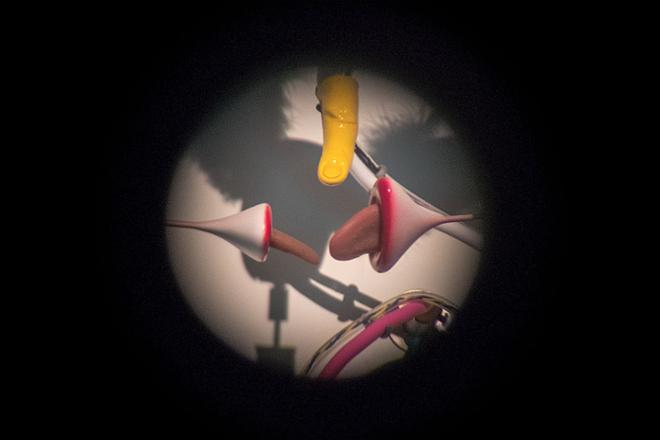 Photograph from a Thesis Exhibition by a 2023 MFA graduate Tomáš Penc featuring a detail view of his kinetic sculpture titled  Hedonic Cupids through a scope. 