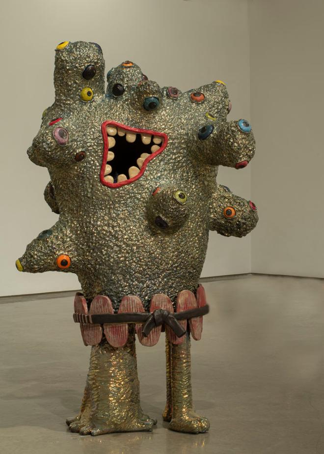 A ceramic sculpture of a creature with many eyeballs.