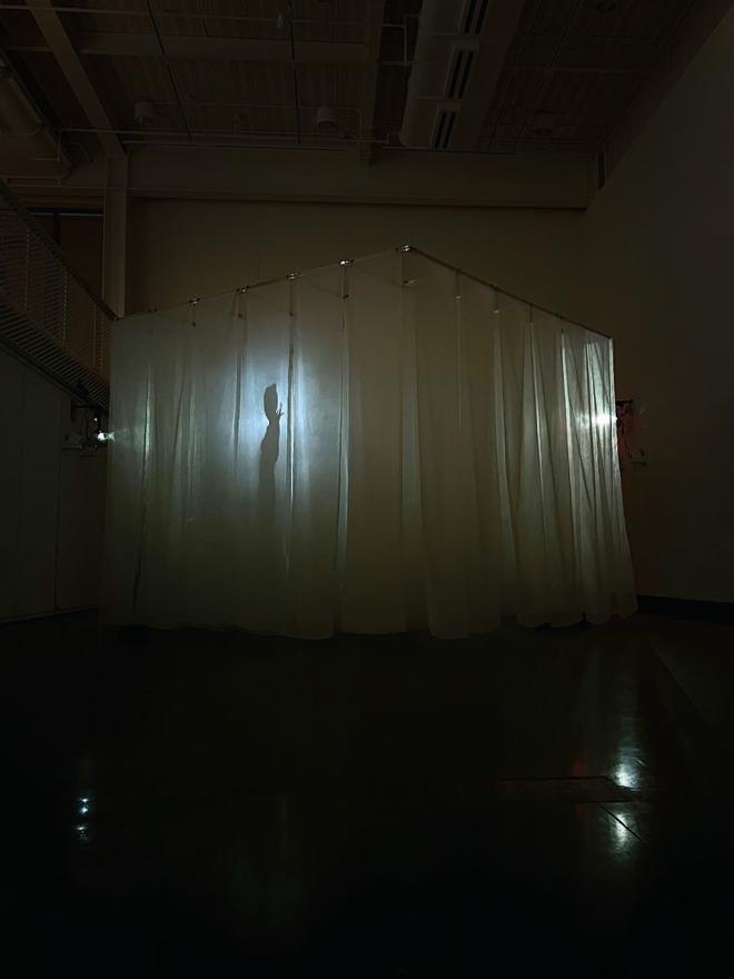 Video projection of a person’s silhouette onto a cube.
