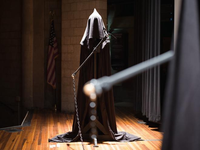 A cloaked figure on stage.