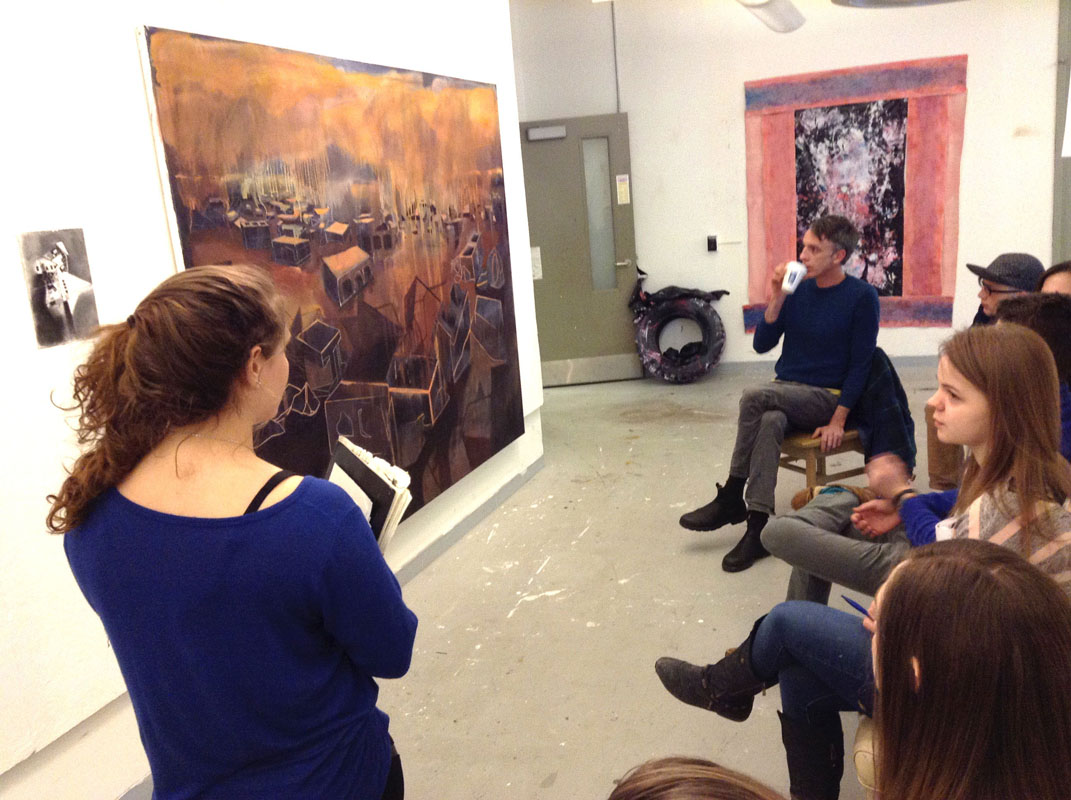Students critiquing a painting at a gallery