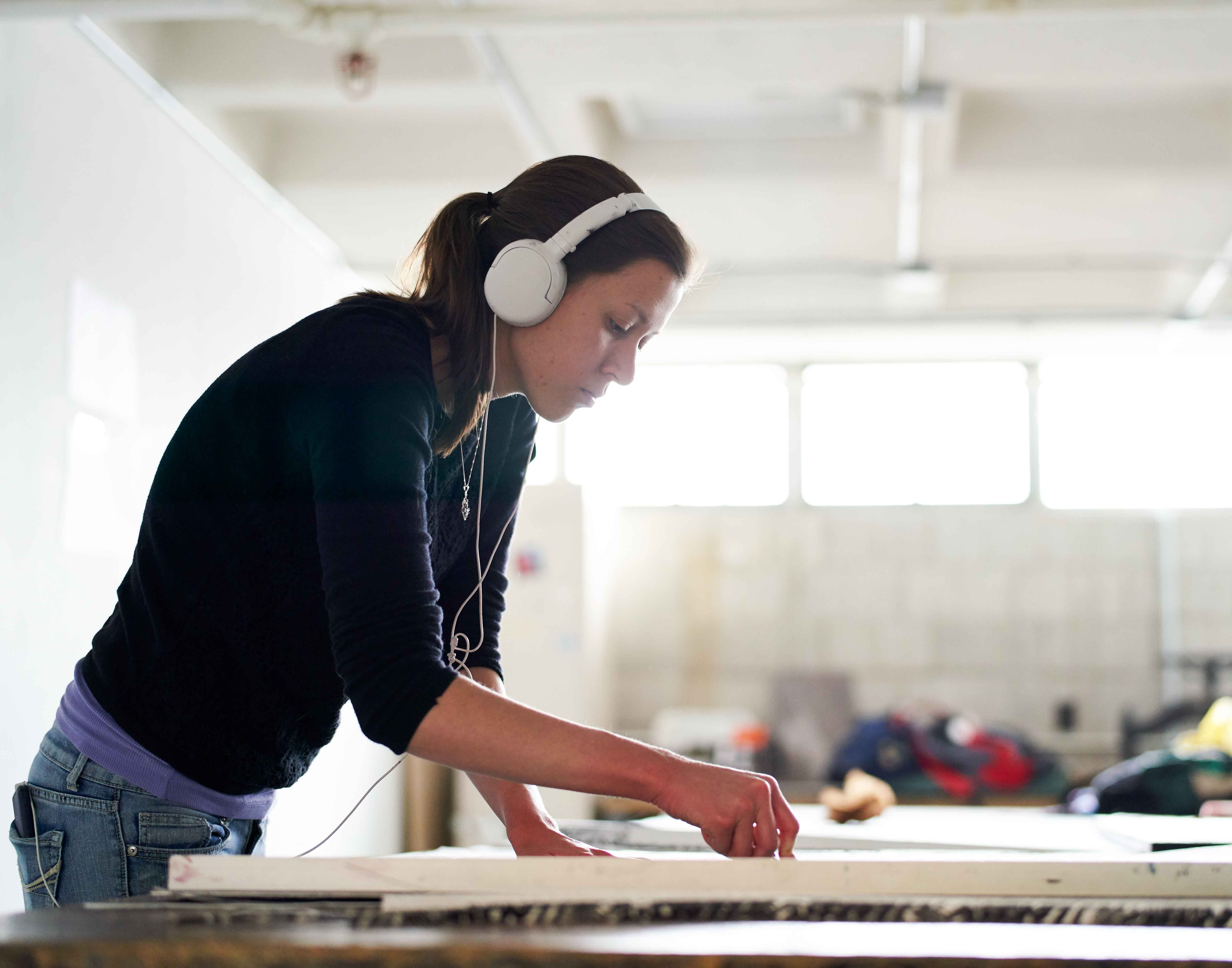Art student in a studio with headphones on