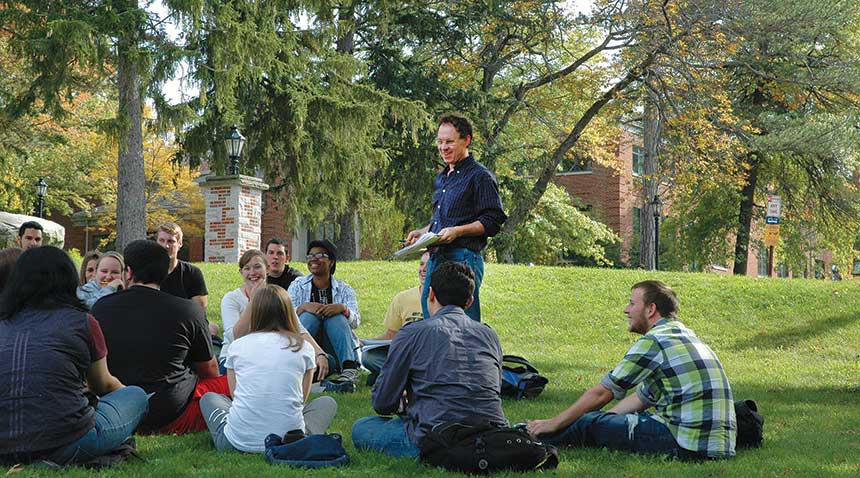 students in class with professor outdoors