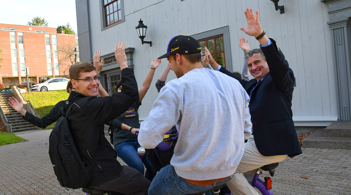 Students and President Zupan riding a bike. 