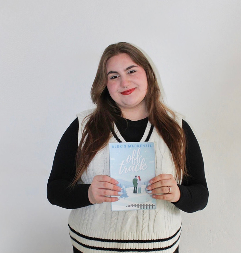 A photo of Alexis Izyk holding her book Off Track