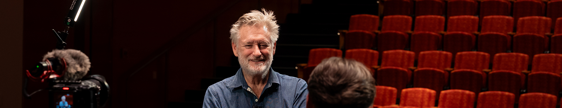 A photo of Bill Pullman being interviewed by an Alfred University student