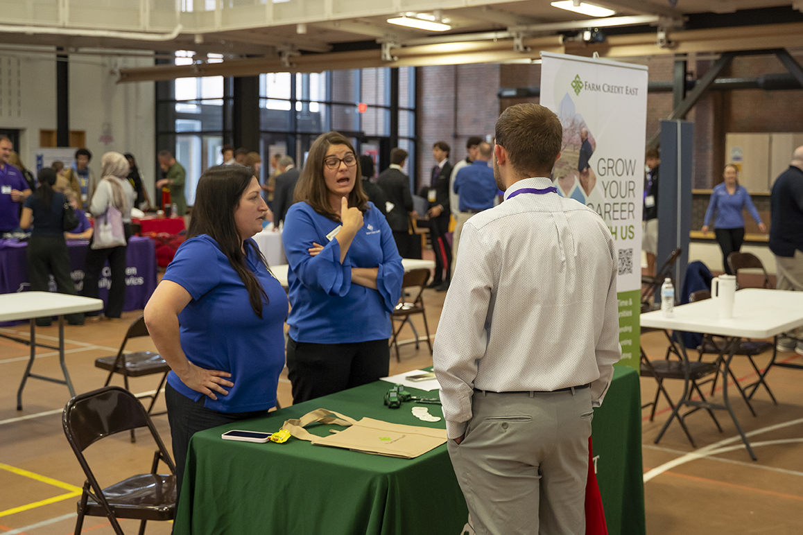 An Alfred University student speaks with two employer representatives from Farm Credit East during the campus Career Fair.