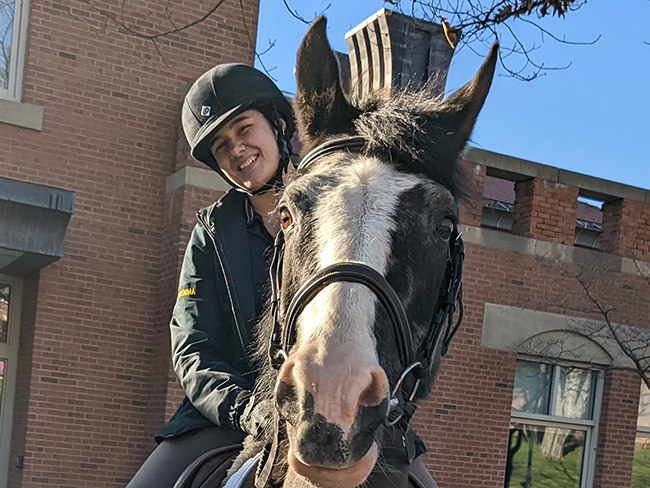 A photo of Emma Johnson riding a horse