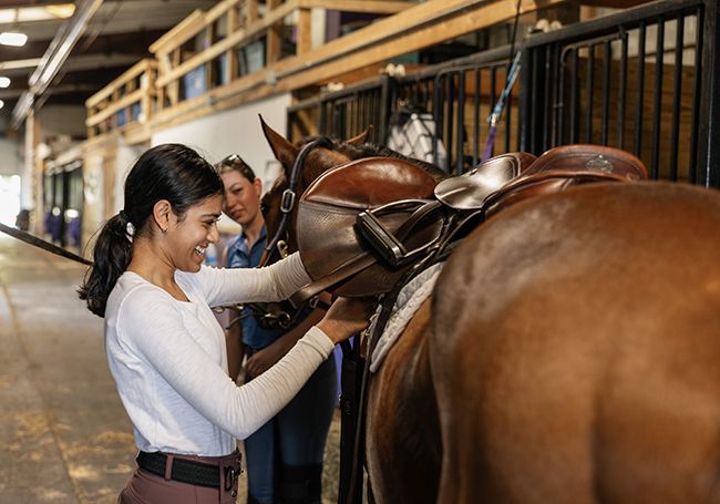 A photo of a high school student petting a horse