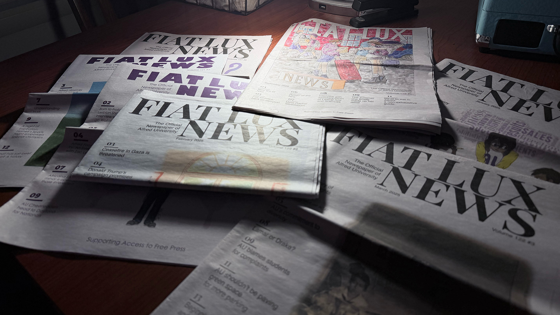 A photo of Fiat Lux newspapers spread out on a desk