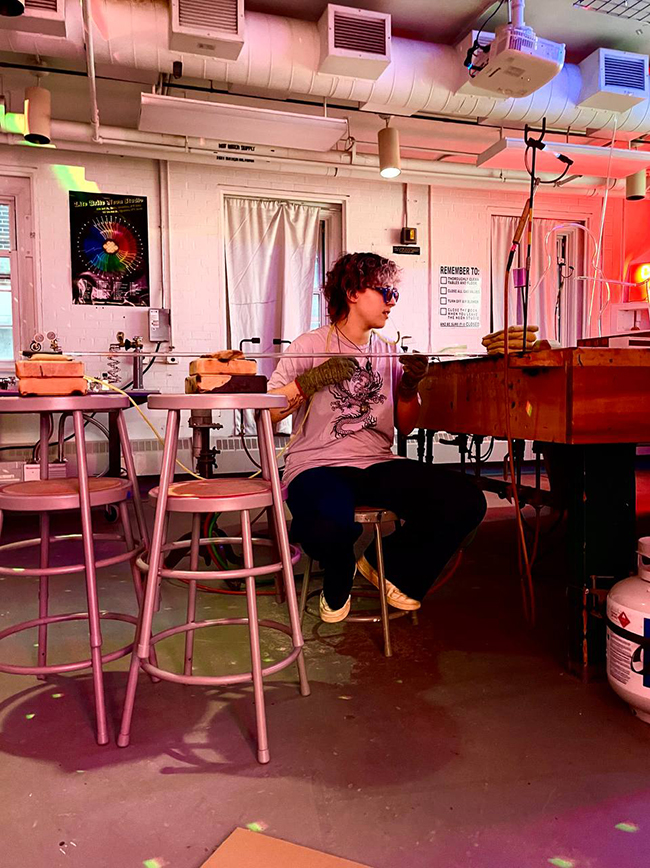 A photo of Han Ramirez-Garcia working with neon in an art lab