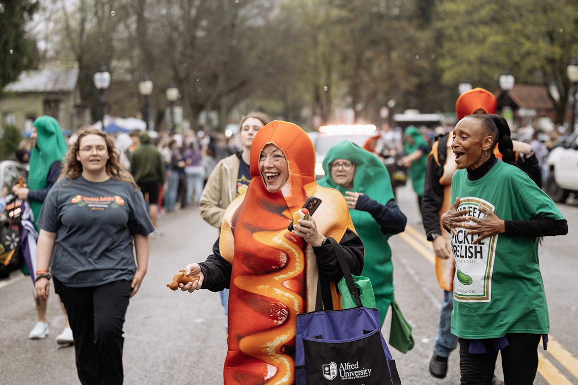 A photo of a woman in a hot dog costume walking down Main Street in Alfred