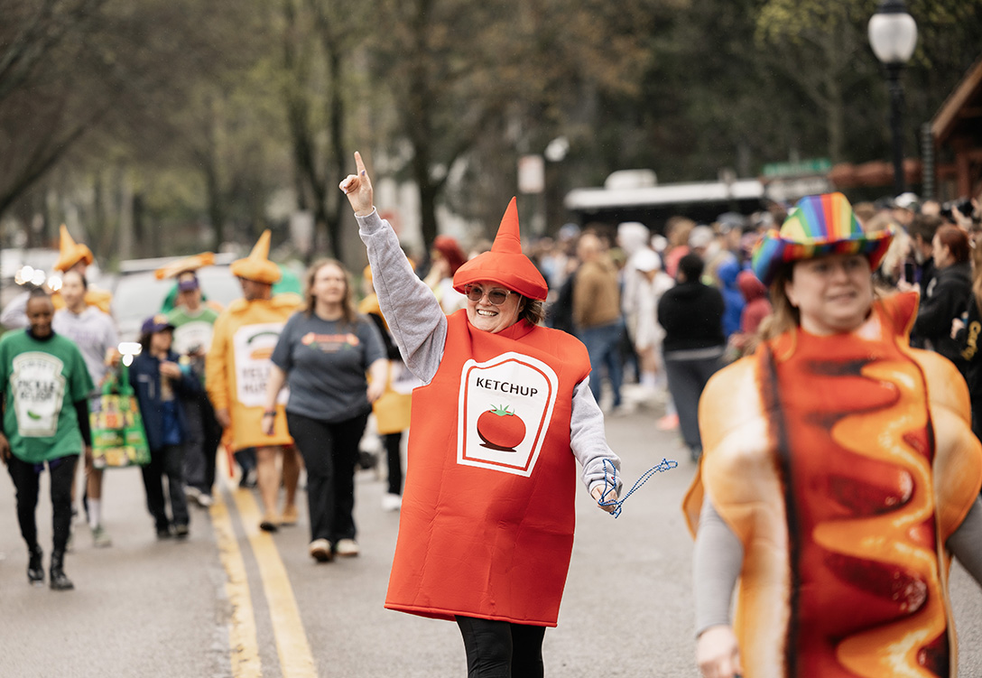A photo of a woman in a ketchup costume walking down Main Street in Alfred