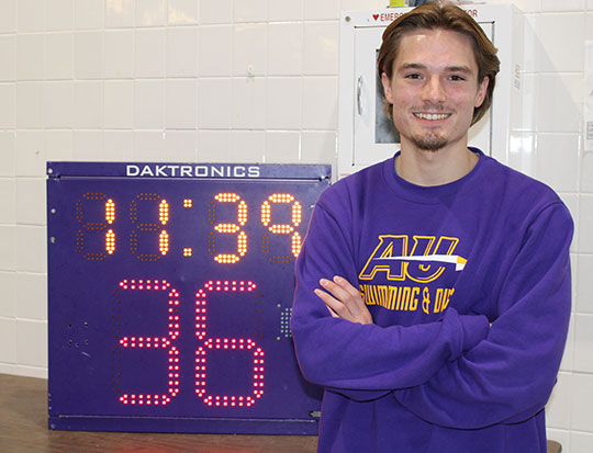 Student Sean Killian with swim pool pace clock