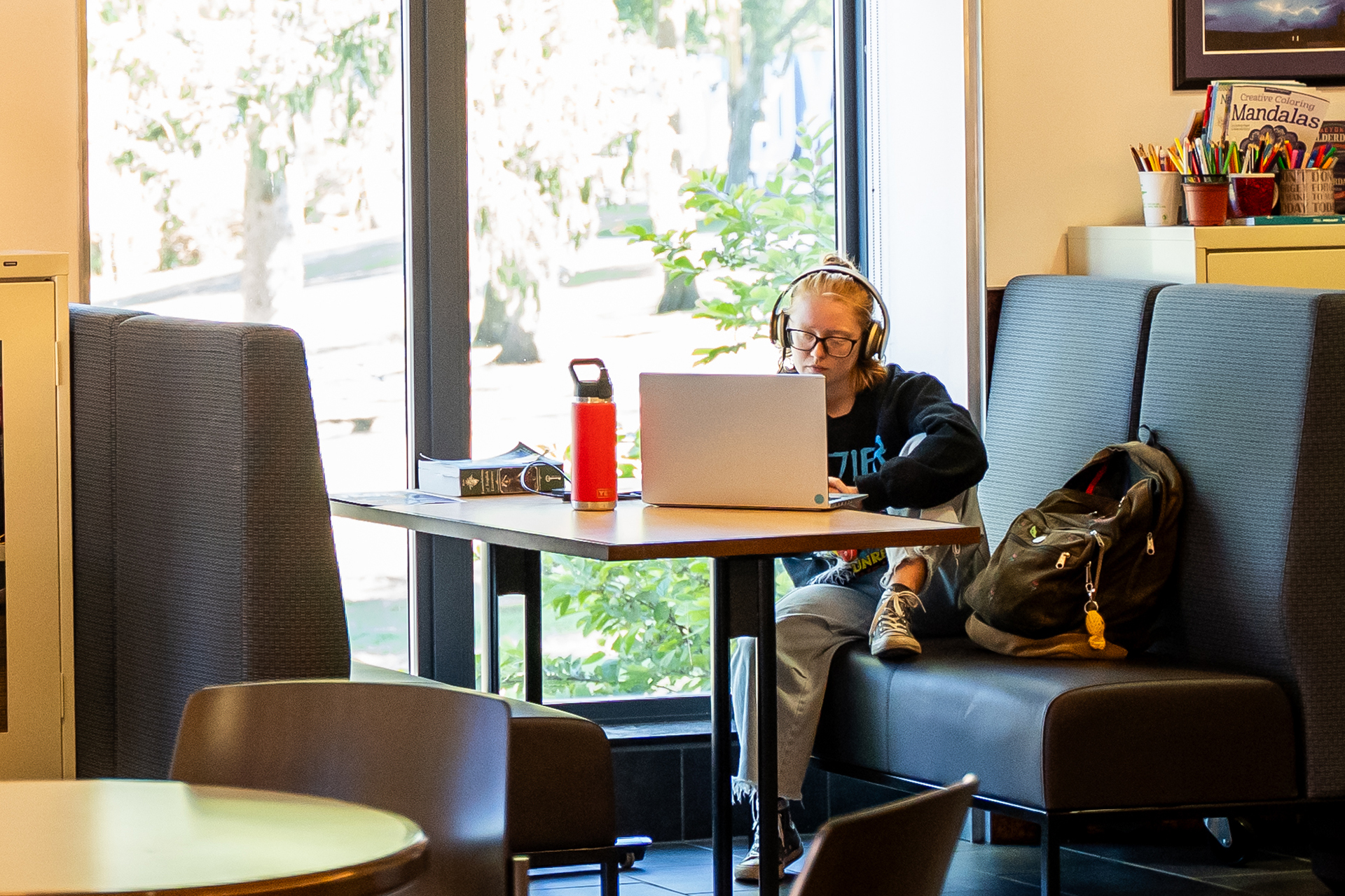 A photo of a student working on their laptop in the library