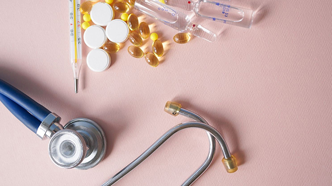 A photo of a stethoscope, pills, and syringe bottles