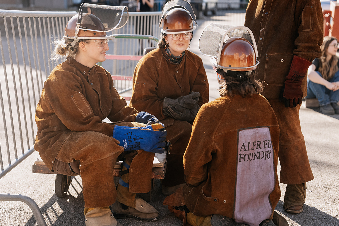 A photo of Alfred University students wearing Alfred Foundry protective jumpsuits