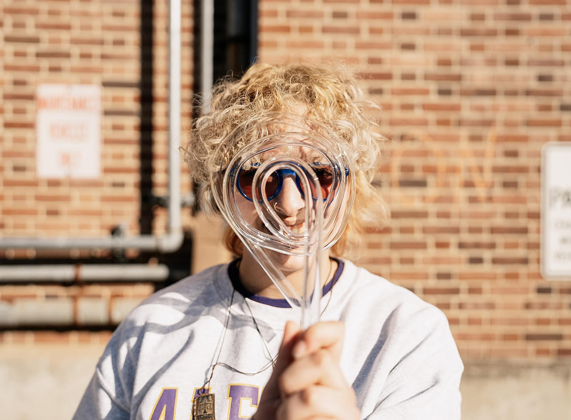 A photo of an Alfred University student holding a neon tube