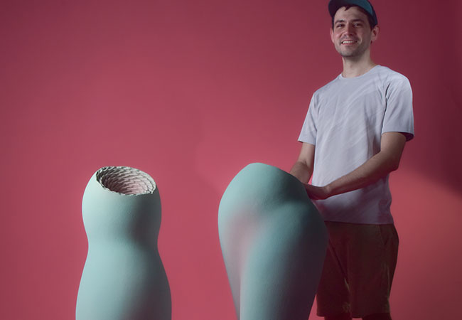 A photo of Uriel Caspi Jr. with an art sculpture